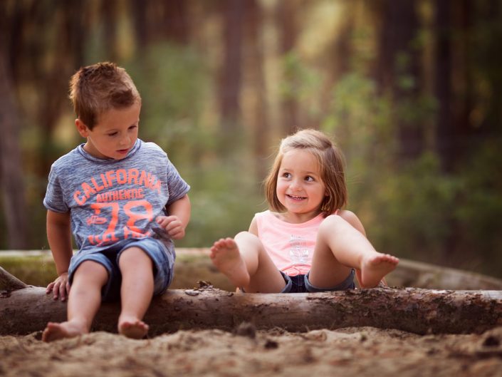 lachende kinderen spelen in het bos